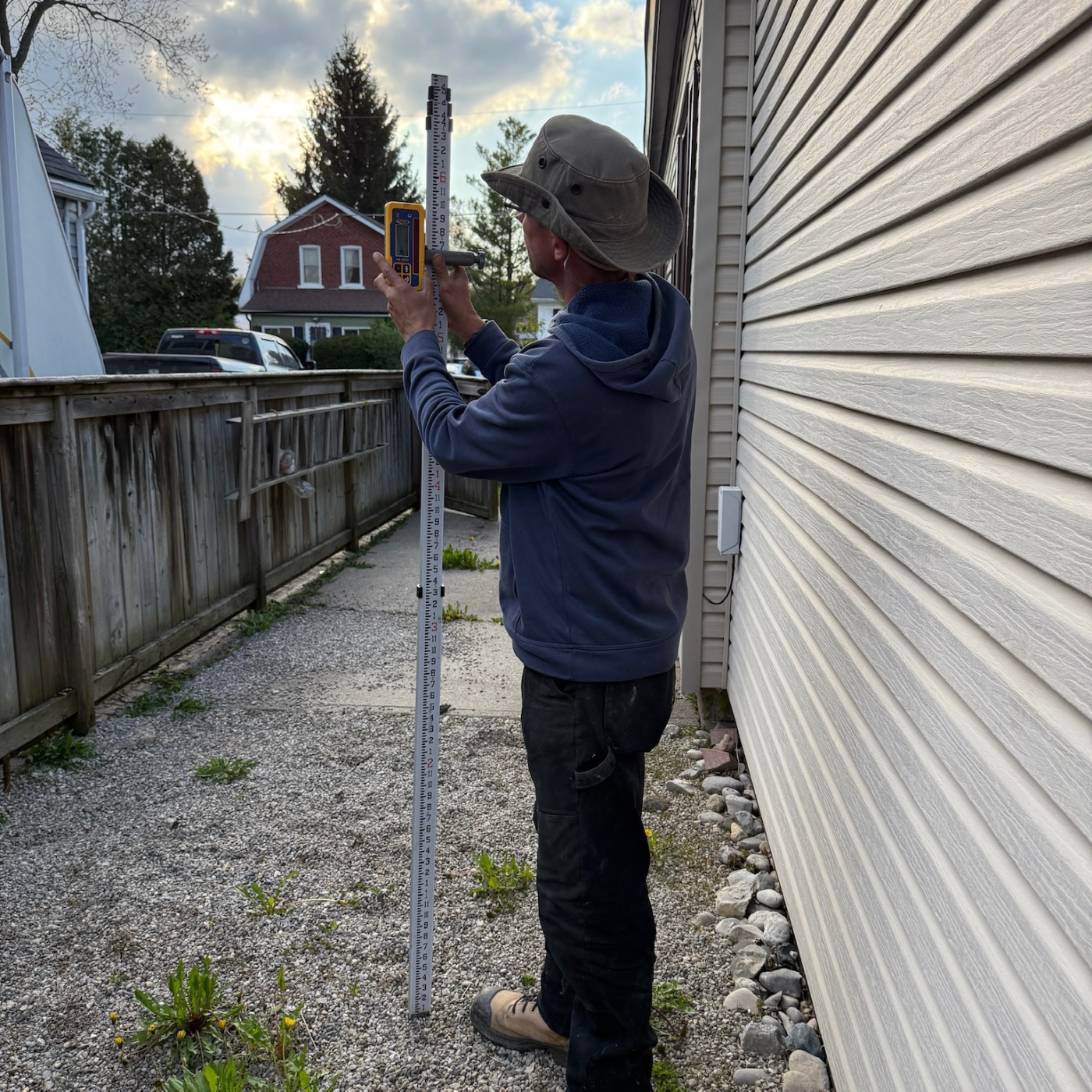 Drainage assessment showing downspout discharge and where roof water enters the yard, a key cause of water pooling near the foundation.