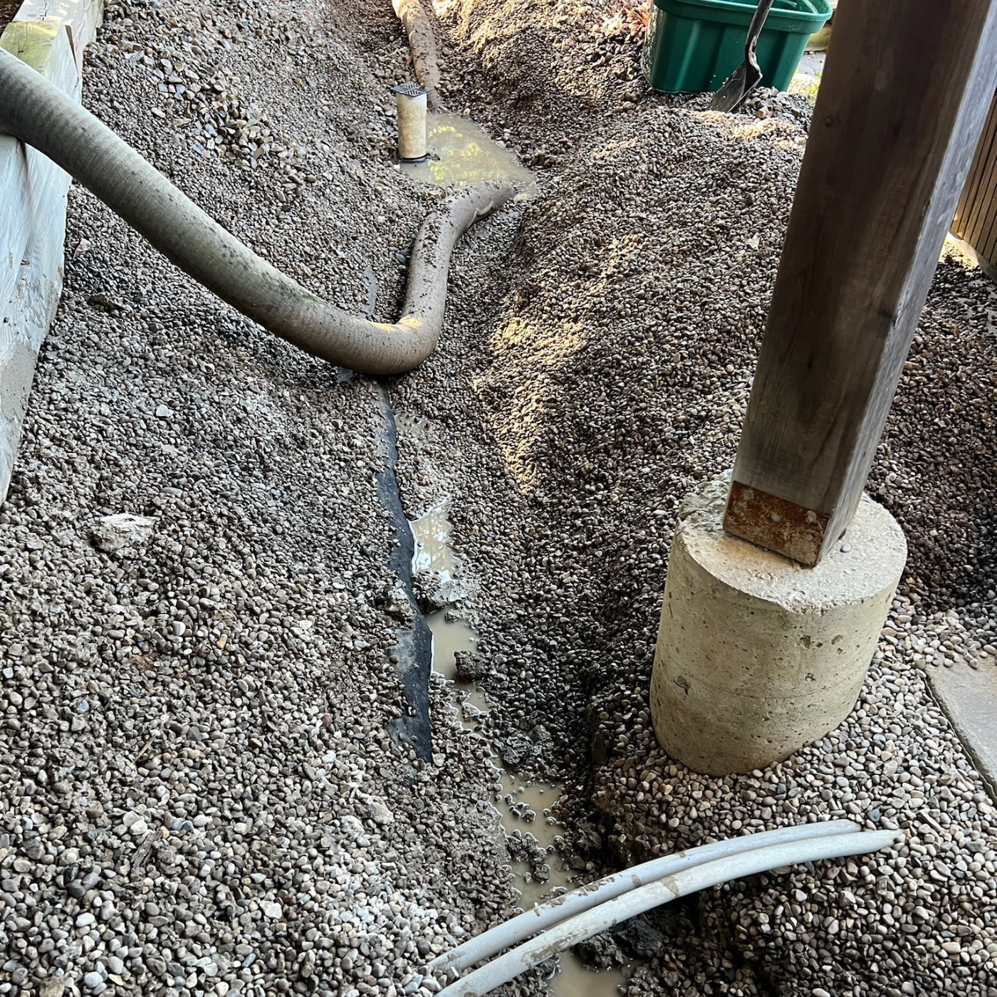 Drainage assessment showing downspout discharge and where roof water enters the yard, a key cause of water pooling near the foundation.